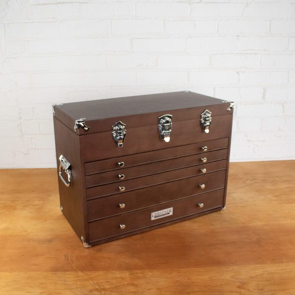 Wooden toolbox with silver handles and multiple drawers.