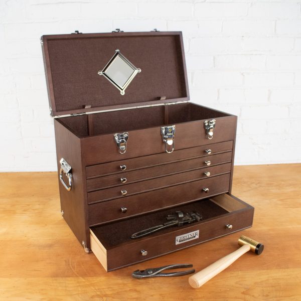 Open wooden toolbox with tools on table.